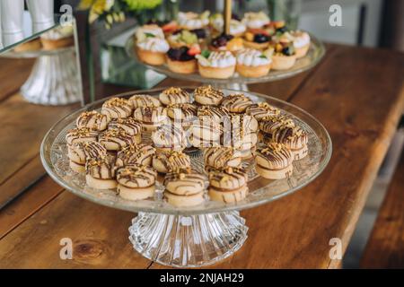 A wooden table with freshly baked donuts, muffins and pastries arranged neatly in a row Stock Photo