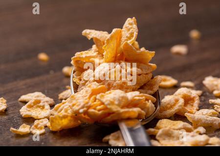 A spoonful of cereal is placed on a rustic wooden table, the perfect image for a breakfast setting Stock Photo