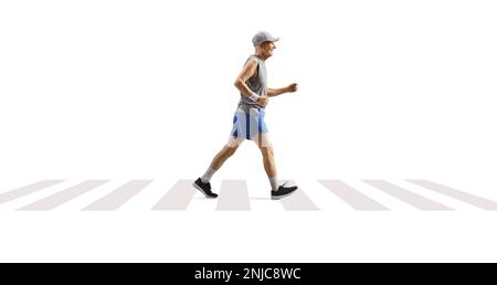 Full length profile shot of an elderly man jogging on a pedestrian crossing isolated on white background Stock Photo