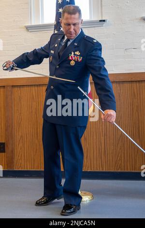 Lt. Col. William Skaggs, director of operations for the 157th Air Intelligence Squadron, sheaths a saber given to him from his family, during his retirement ceremony, Aug. 6, 2022, at Jefferson Barracks Air National Guard Base, St. Louis, Missouri. Skaggs served for 37 years. Stock Photo