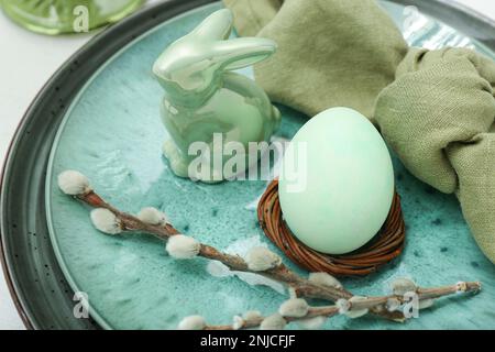 Stylish table setting with Easter egg, willow branches and ceramic bunny, closeup Stock Photo