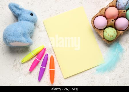 Blank card with Easter rabbit, eggs and markers on grunge background Stock Photo