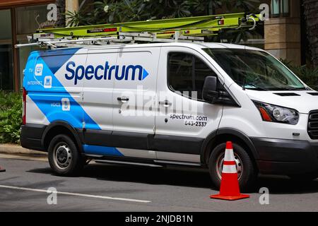 Honolulu, HI - June 20, 2020: Spectrum cable provider logo name on a service vehicle parked on a sunny street. Stock Photo