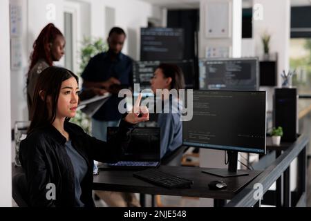 Concentrated web developer working with hologram and coding language in programming it office room. System engineer analyzing holographic script and augmented reality to develop new server interface. Stock Photo
