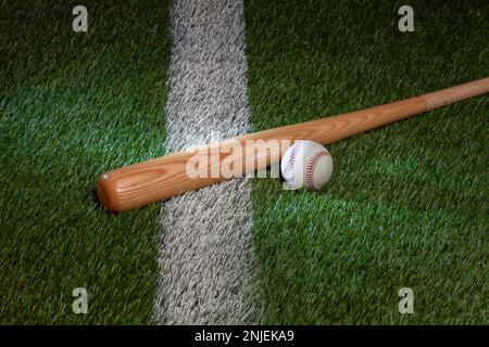 Baseball and bat on grass field with white stripe Stock Photo