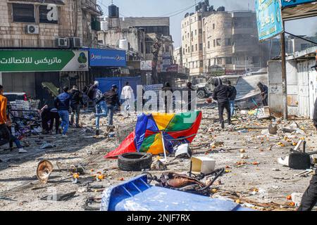 Nablus, Palestine. 22nd Feb, 2023. Palestinian youths throw goods and vegetables at the vehicles of the Israeli army during the clashes at the vegetable market in the old city of Nablus in the occupied West Bank. Clashes broke up between Palestinians and Israeli army after the Israeli army broke into the shelter in which Palestinian gunmen from the Lions' Den groups were hiding in the old town of Nablus, killing four gunmen and six civilians who were present at the market during the raid. Credit: SOPA Images Limited/Alamy Live News Stock Photo