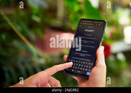 February 5, 2023, Mirissa, Sri Lanka. Using OpenAI chatGPT on phone. Woman chats with artificial intelligence. Person tests neural network language Stock Photo
