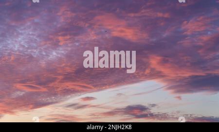 Sunset sky. Cirrocumulus and cirrostratus clouds during sunset. Beautiful dramatic sunset sky background. Selective focus included. Noisy photo Stock Photo