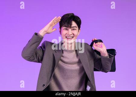 handsome Korean young man leaving work on time with briefcase Stock Photo