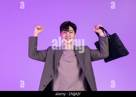 handsome Korean young man leaving work on time with briefcase Stock Photo