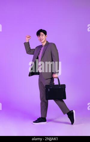 handsome Korean young man leaving work on time with briefcase Stock Photo