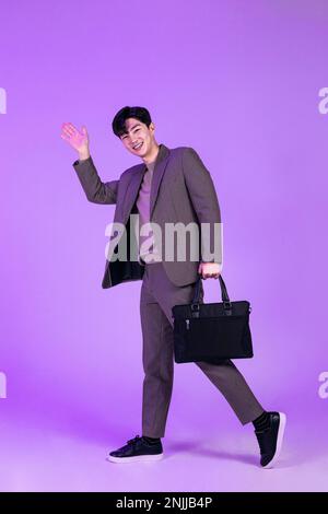 handsome Korean young man leaving work on time with briefcase Stock Photo