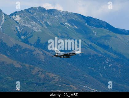 A U.S. Air Force F-16 Fighting Falcon assigned to the 510th Fighter Squadron performs a low pass at Aviano Air Base, Italy, Aug. 8, 2022. A low pass maneuver involves diving low and making another pass around the flight zone instead of touching down and landing on the flightline. Stock Photo