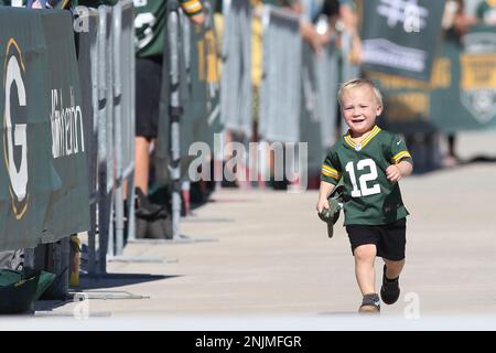 ASHWAUBENON, WI - JULY 27: Green Bay Packers linebacker Isaiah McDuffie  (58) bikes with a fan during Green Bay Packers training camp at Ray  Nitschke Field on July 27, 2022 in Ashwaubanon