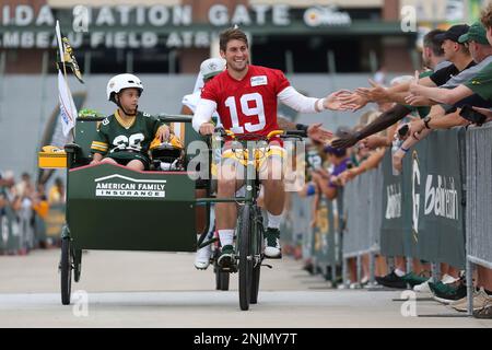 ASHWAUBENON, WI - JULY 27: Green Bay Packers linebacker Isaiah McDuffie  (58) bikes with a fan during Green Bay Packers training camp at Ray  Nitschke Field on July 27, 2022 in Ashwaubanon