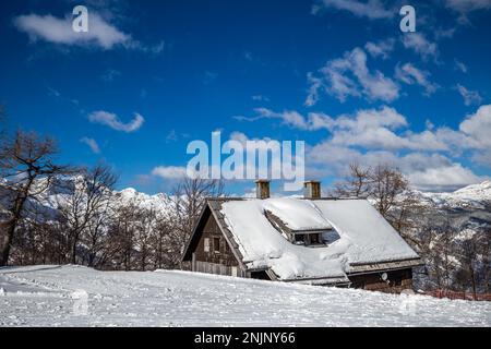 Bohinj, Slovenia - Winter view of the snowy ski hut at the top of Vogel mountain in the Alps at Triglav National Park on a sunny winter day with blue Stock Photo