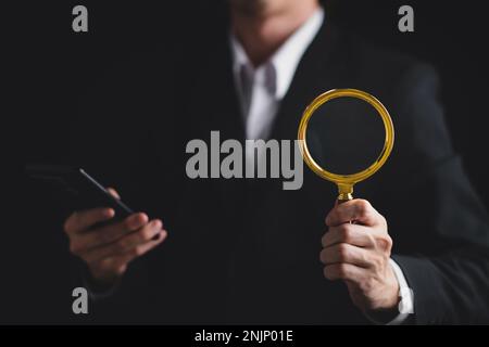 Businessman use magnifying glass with smartphone for CRM, Customer Relationship Management. HR, human resource search personnel. Global structure cust Stock Photo