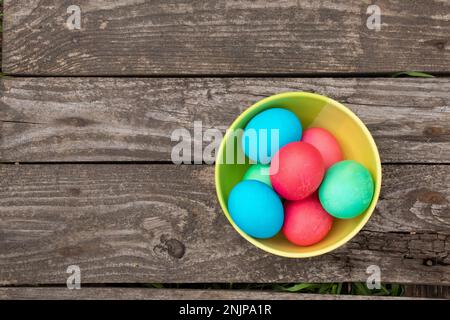 multi-colored easter eggs lie on an old wooden board, on quarantine on Easter Stock Photo