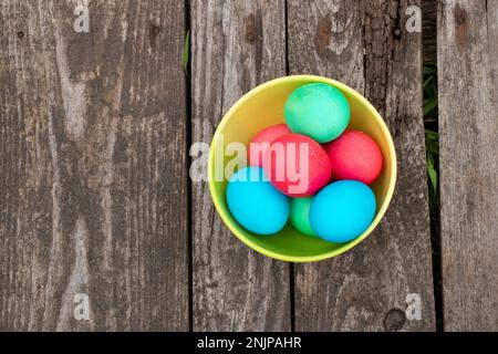 multi-colored easter eggs lie on an old wooden board, on quarantine on Easter Stock Photo