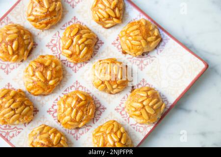 Penellets. Small sweets of various shapes, made from almond and potato dough, and covered with almonds or pine nuts. Stock Photo