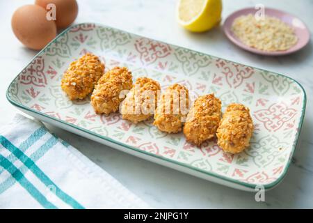 Penellets. Small sweets of various shapes, made from almond and potato dough, and covered with almonds or pine nuts. Stock Photo