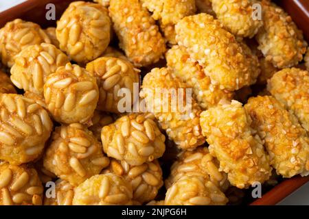 Penellets. Small sweets of various shapes, made from almond and potato dough, and covered with almonds or pine nuts. Stock Photo