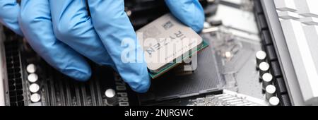 Tbilisi, Georgia - July 26, 2022: Installation of third generation Ryzen processor on motherboard Stock Photo