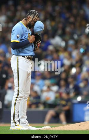 Milwaukee Brewers' Devin Williams hands his glove to an umpire during the  eighth inning of a baseball game against the New York Mets Sunday, Sept.  26, 2021, in Milwaukee. The Brewers defeated