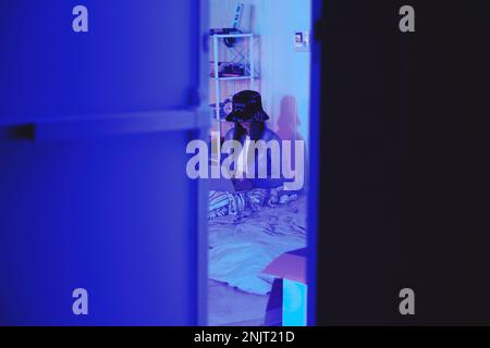 Programmer, hide or neon in night coding, web 3.0 programming or phishing software mock up in off grid door. Woman, hacker or developer on technology Stock Photo
