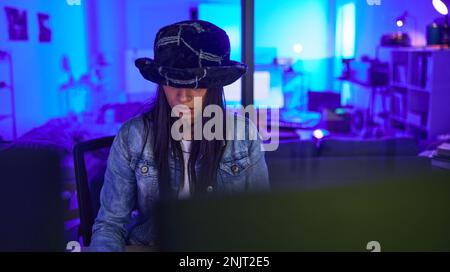 Hacker, cybersecurity and programming with woman in home for ransomware, database or it at night. Neon, coding and technology with girl programmer and Stock Photo