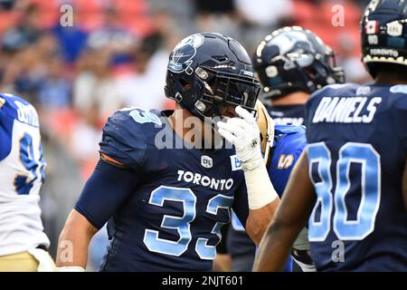 Toronto Argonauts running back Andrew Harris (33) is mobbed by teammates  after scoring a touchdown against the Montreal Alouettes during the first  half of a CFL Eastern Final football game in Toronto