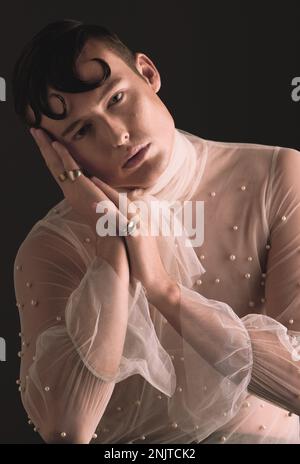 Gender neutral, vintage fashion and portrait of person with designer clothing and faux pearls in studio. Isolated, black background and lgbtq or gay Stock Photo