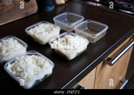 Meal prep. Stack of home cooked rice and chicken dinners in containers ready to be frozen for later use as quick and easy ready meals. Food prepping Stock Photo