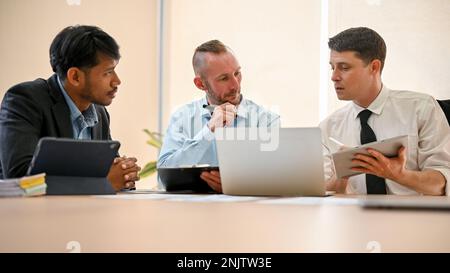 Team of professional business financial investment analysts analyzing financial data, discussing, brainstorming and working together in the meeting ro Stock Photo