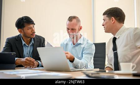 Team of business financial analysts discussing project, sharing their business ideas and working together in the meeting room. Stock Photo
