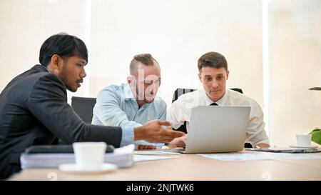 Professional business financial analysts or financial consultants are discussing work, looking at laptop screen, having a financial meeting in the mee Stock Photo