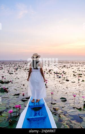 Asian women in a boat at the Beautiful Red Lotus Sea in Udon Thani in northern Thailand. Flora of Southeast Asia.  Stock Photo
