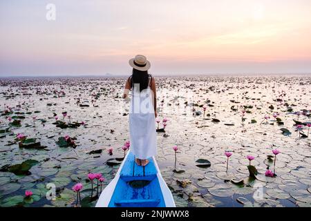 Asian women in a boat at the Beautiful Red Lotus Sea in Udon Thani in northern Thailand. Flora of Southeast Asia.  Stock Photo