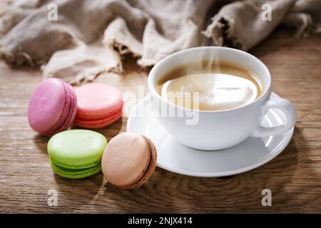 Cup of coffee and macaroons on wooden table Stock Photo