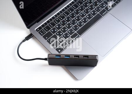 Top view of a multiport usb expansion adapter placed on a laptop isolated on white background. Professional connectivity solutions for modern computer Stock Photo