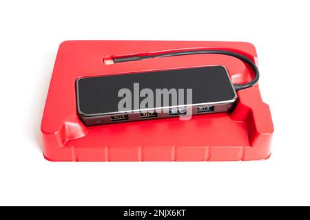 Multiport USB-C hub packaged in a vibrant red retail box, isolated on a white background. Stock Photo