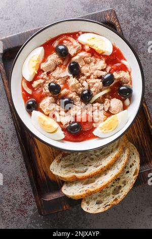 Ensalada Murciana is a traditional Spanish salad made with a combination of tomatoes, onions, tuna, hard-boiled eggs, and black olives closeup on the Stock Photo
