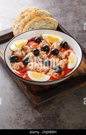 Murcian salad or mojete, a traditional fresh and light recipe that is prepared with tomato, canned tuna, black olive, egg and onion closeup on the pla Stock Photo