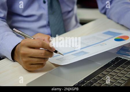 businessman or accountant checking corporate Information accounting and tax documents with laptop computer. Stock Photo