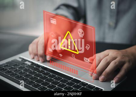 Businessman programmer, developer using laptop computer with triangle caution warning sign. system hacked on computer network cybersecurity vulnerabil Stock Photo