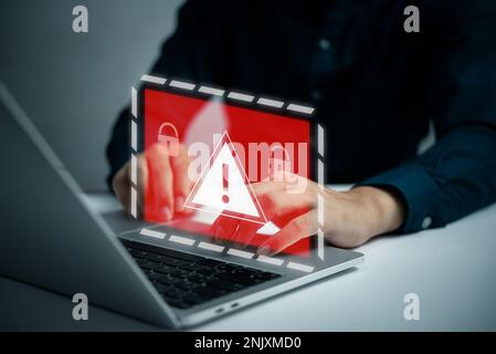 Businessman programmer, developer using laptop computer with triangle caution warning sign. system hacked on computer network cybersecurity vulnerabil Stock Photo