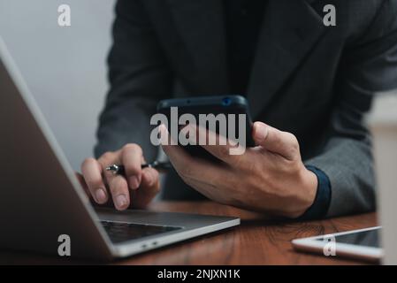 businessman working searching information during online on laptop computer with modern devices. Stock Photo