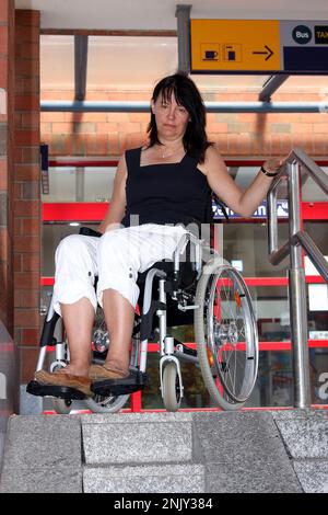 woman in a wheelchair at the with pram ramp at the train station, not ...
