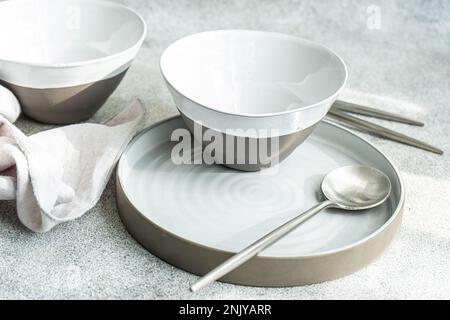 Minimalistic white and grey table setting on concrete table Stock Photo