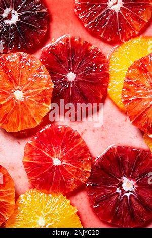 Top view background of colorful fresh juicy grapefruit and orange slices placed in water for shots and cocktails preparation Stock Photo
